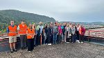 Lehrer:innen, Direktorin und Mitarbeiter der RailCargo stehen auf dem Aussichtsdach für ein Gruppenfoto zusammen