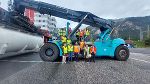 Gruppenfoto der teilnehmenden Lehrer:innen, der Direktorin und Mitarbeitern der RailCargo auf und vor einem Reachstacker
