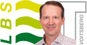 Portrait von Gerald Koß vor LBS Voitsberg Logo