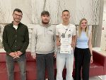Die Schulsieger:innen vom PB-Quiz stehen gemeinsam mit Herrn Kitting zusammen. Der Schulsieger präsentiert seine Urkunde.