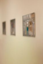 Drei gerahmte Bilder hängen an einer hellen Wand. Die Motive sind nicht klar erkennbar.