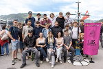 Gruppe junger Menschen posiert lächelnd vor einem pinkfarbenen Banner mit dem Schriftzug 'LBS Eiswald'. Im Hintergrund eine ländliche Landschaft.