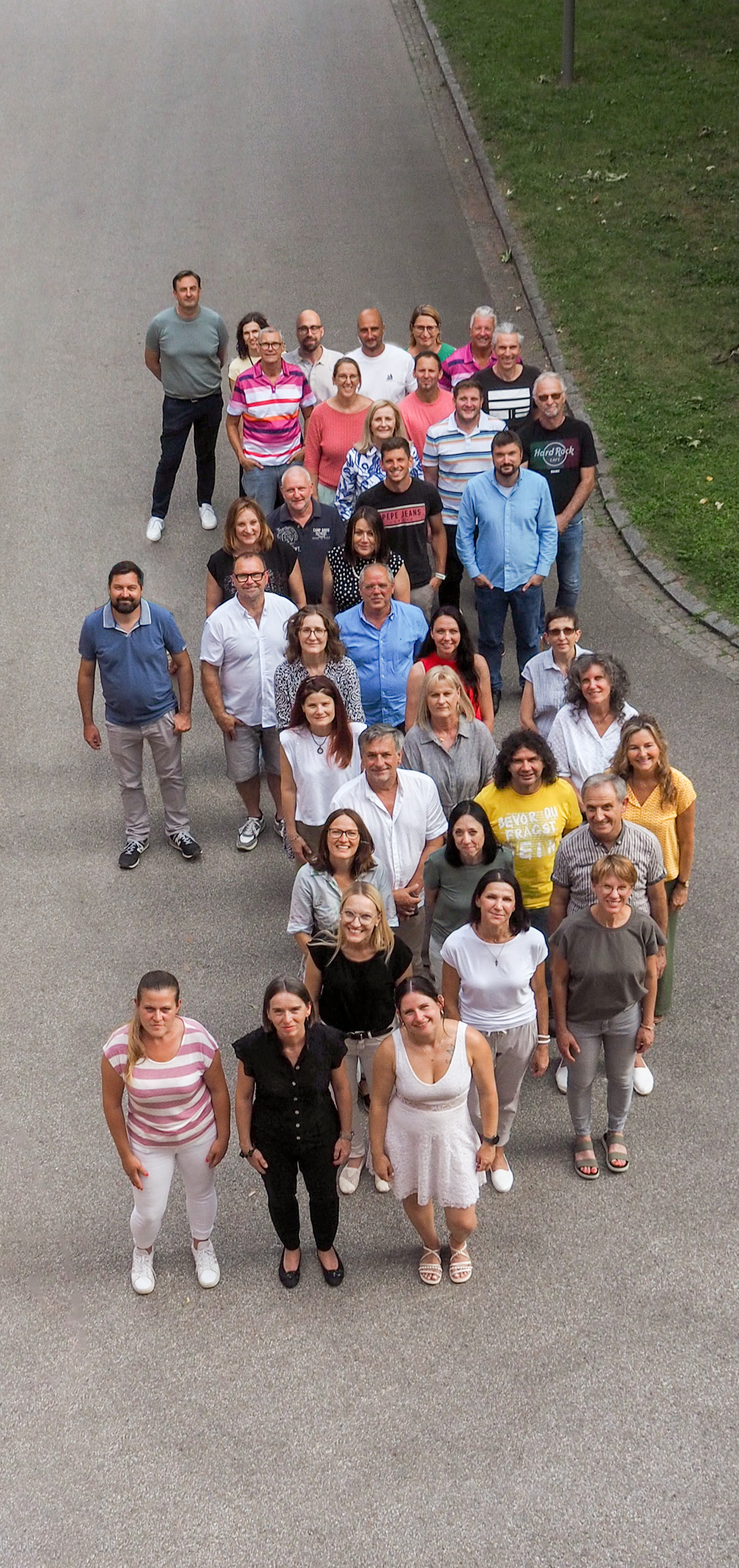 Foto der Lehrerinnen und Lehrer vor einem altrosa Gebäude 