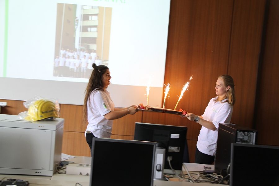 Rabia und Melanie bringen eine Torte mit Spritzkerzen