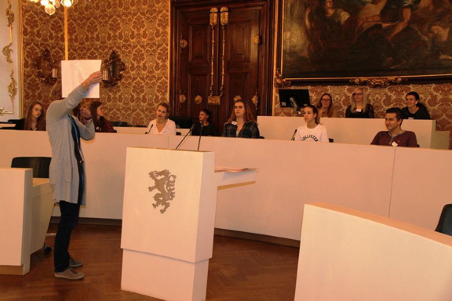 Eine Gruppe der Schüler/innen nimmt Platz auf der Regierungsbank bzw. der Bank der Landtagspräsident/inn/en